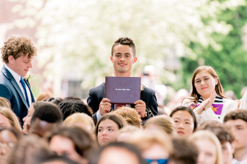 Photo of a student holding a diploma. Link to Life Stage Gift Planner Under Age 45 Situations.