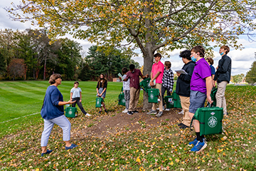 A class picking up leaves outside. Links to Tangible Personal Property